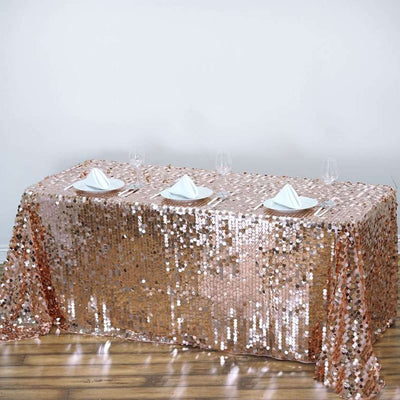 Rose gold sequin tablecloth draped over a table with elegant dining setup.