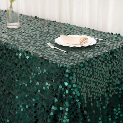Green sequin tablecloth on a table with a plate and napkin.