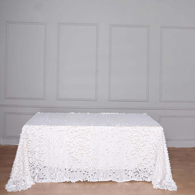 White table with textured lace overlay on a plain background.