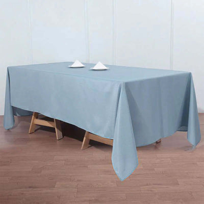 Blue tablecloth draping over a wooden table with decorative plates.