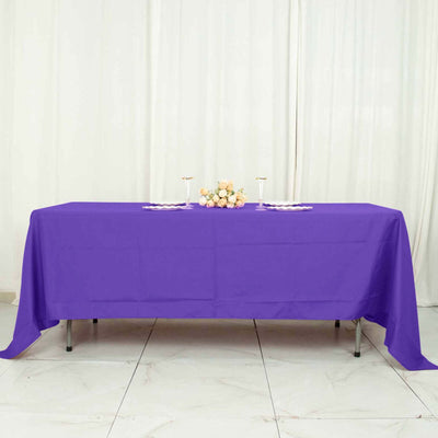 Purple tablecloth draped over a table with floral centerpiece