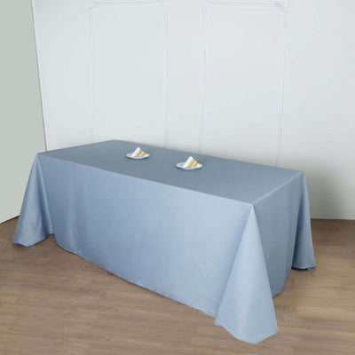 Blue tablecloth draped over a table with two plates on top.