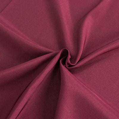 Burgundy fabric with smooth texture and draping appearance