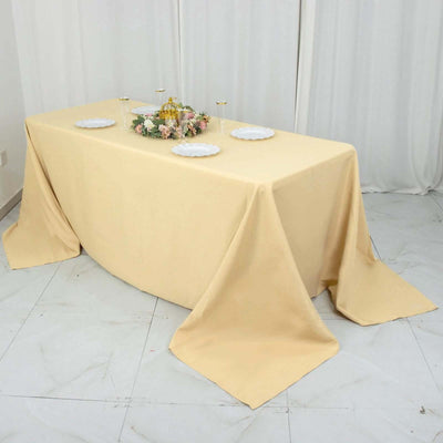 Elegant beige tablecloth draping over a banquet table with floral centerpiece.