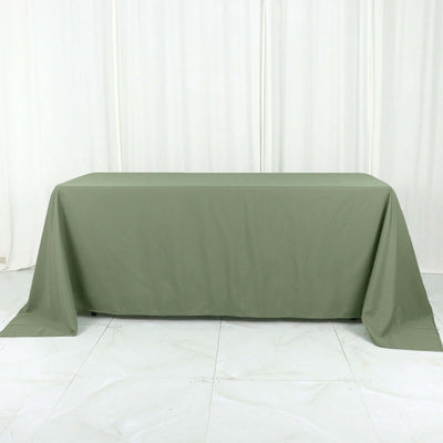 Olive green tablecloth on a table against a neutral backdrop