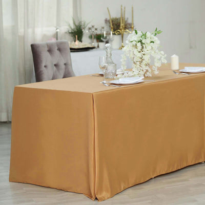 Elegant gold tablecloth draping over a dining table with floral centerpiece.