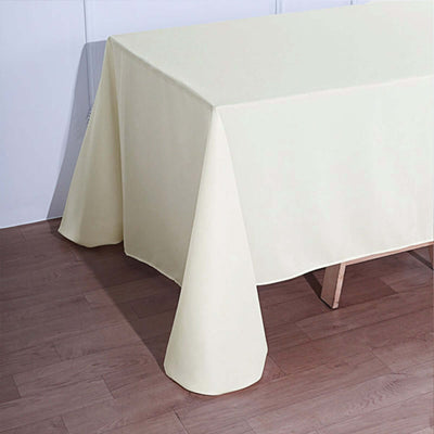 Yellow tablecloth draped over a table on a wooden floor.