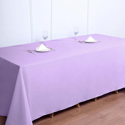 Purple tablecloth draped over a table set for dining with glasses and napkins.
