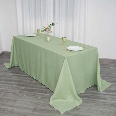 Elegant green tablecloth draped over a dining table with decorative elements.
