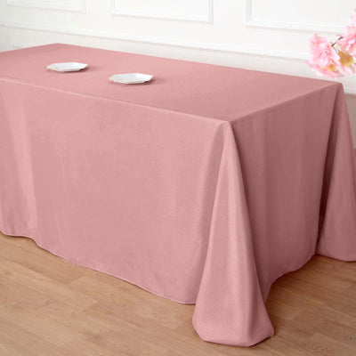 Pink tablecloth draped over a table with two white plates on top.