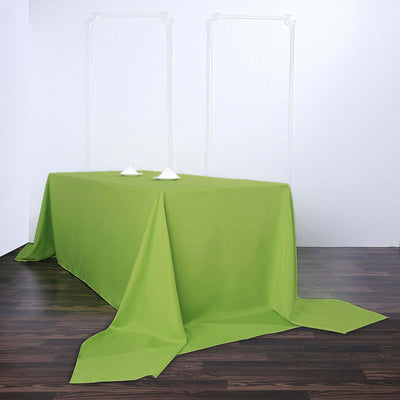 Green tablecloth draped over a table in a minimalist setting.