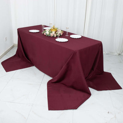 Burgundy tablecloth draped elegantly over a table with floral centerpiece.