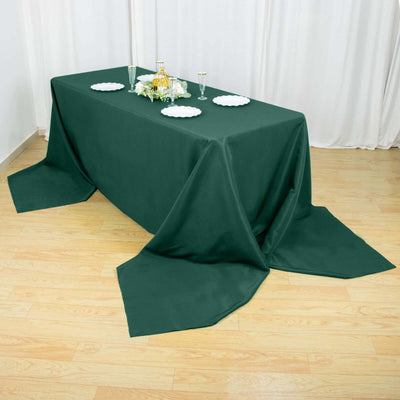 Green tablecloth draped over a table for an elegant dining setup.