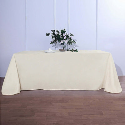Cream tablecloth draped over a table with a floral centerpiece