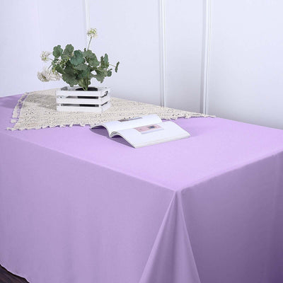 Purple tablecloth with a decorative lace runner and a book on a table.