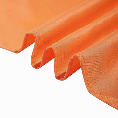Vibrant orange fabric with a smooth texture and flowing drape.