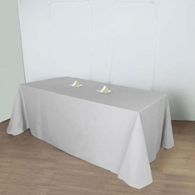 Gray tablecloth draped over a table with plates on top.