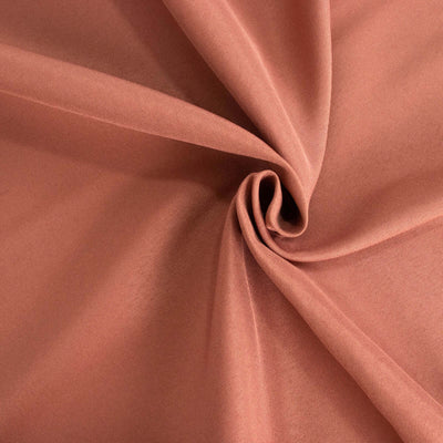 Soft terracotta fabric texture in elegant swirl pattern.