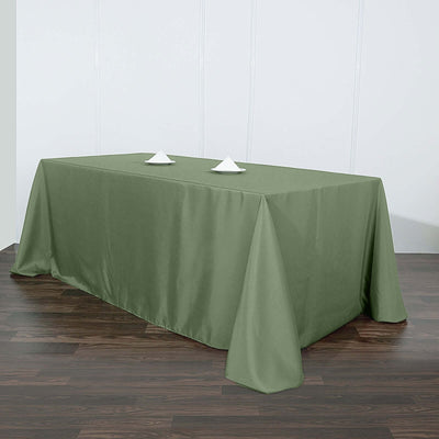 Olive green tablecloth draped over a rectangular table with two napkin holders.