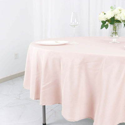 Pink tablecloth draped elegantly on a table with wine glass and flowers