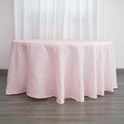 Pink tablecloth draped elegantly over a round table in a bright setting.