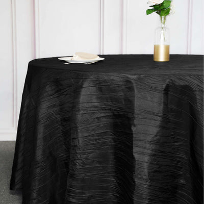 Black tablecloth with textured design on a round table.