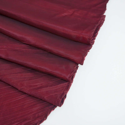 Burgundy textured fabric draped in elegant folds