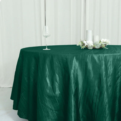 Green tablecloth draped over a round table with decorative elements.