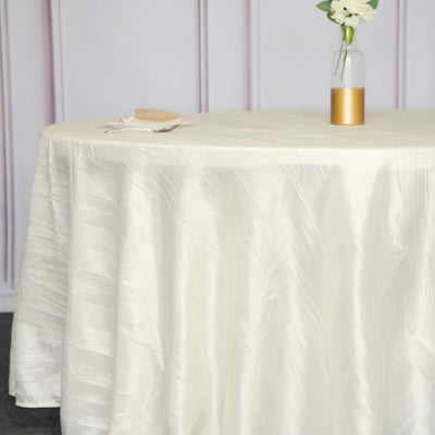Elegant cream tablecloth draped over a round table with a floral centerpiece.