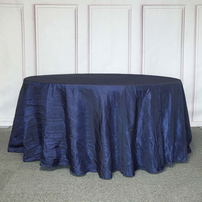 Navy blue round tablecloth on a textured gray surface.
