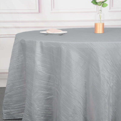 Elegant gray tablecloth draped over a round table with a flower vase.