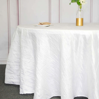 White tablecloth draped over a round table in a styled setting.