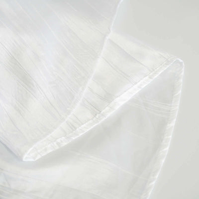 White textured fabric with subtle stripes, softly draped.