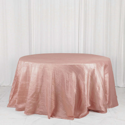 Pink satin round tablecloth on a white backdrop.