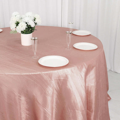 Elegant rose tablecloth with white plates and floral centerpiece.