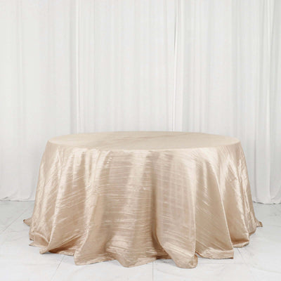 Beige satin tablecloth on a round table against a plain background