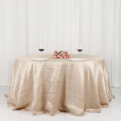 Elegant round table set with wine glasses and a floral centerpiece.