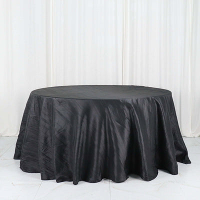 Round black tablecloth with elegant draping.