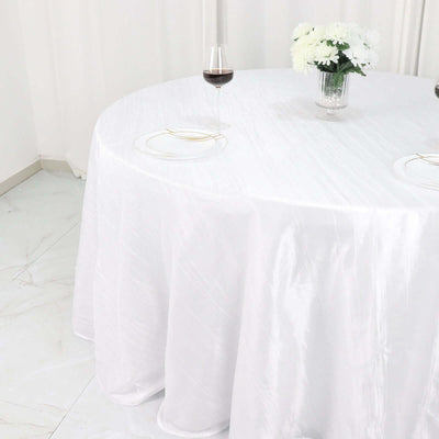 White round tablecloth on a dining table with wine glass and flowers.