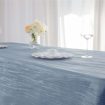 Elegant blue tablecloth with floral centerpiece and glassware.
