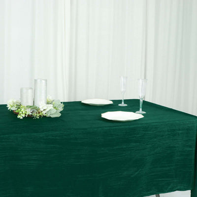Elegant green tablecloth with white plates and glassware, perfect for dining setups.