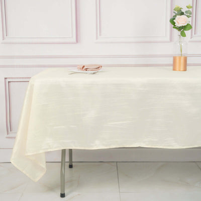 Elegant cream tablecloth draped over a table with floral decor.