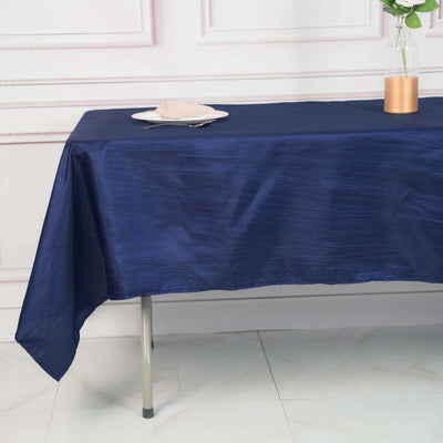 Navy blue tablecloth draped elegantly over a table with a plate and vase.