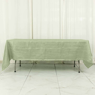 Green tablecloth draped on a table in a light-filled setting.