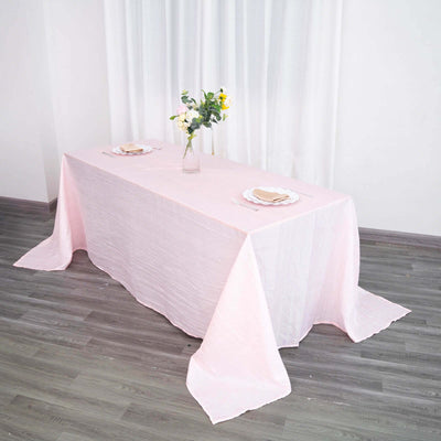 Pink tablecloth draped elegantly over a table with a floral centerpiece.