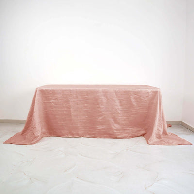 Pink textured tablecloth on a plain surface