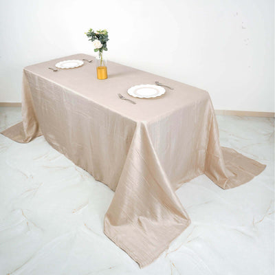 Elegant beige tablecloth draped over a table set for dining.