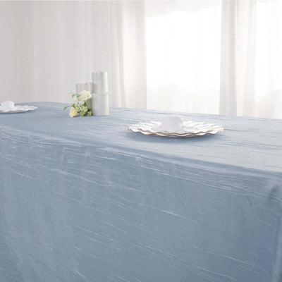 Light blue tablecloth draped elegantly over a table with decorative plates and flowers.