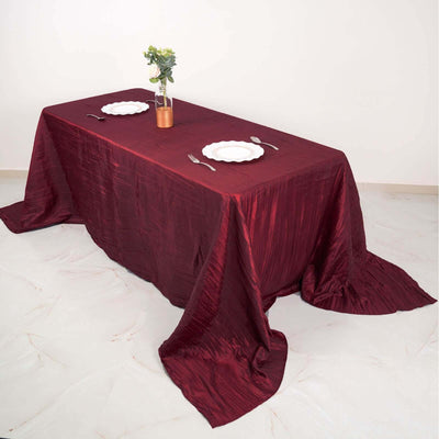 Elegant burgundy tablecloth draped over a table set for dining.