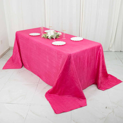Pink tablecloth draped over a table set for an elegant event.